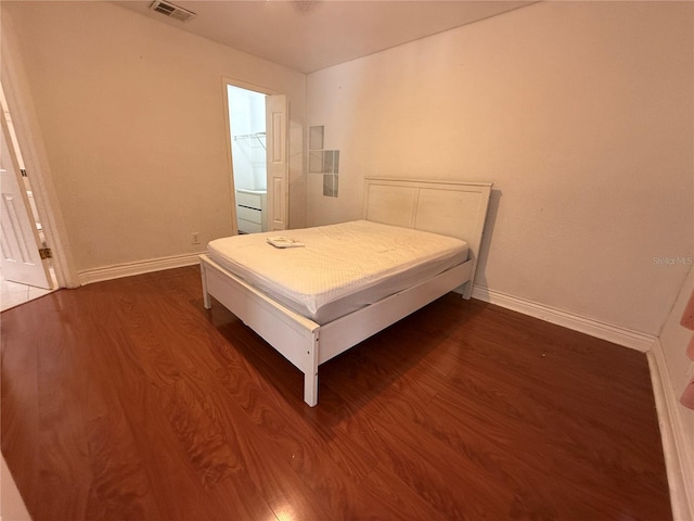 bedroom with dark wood-type flooring