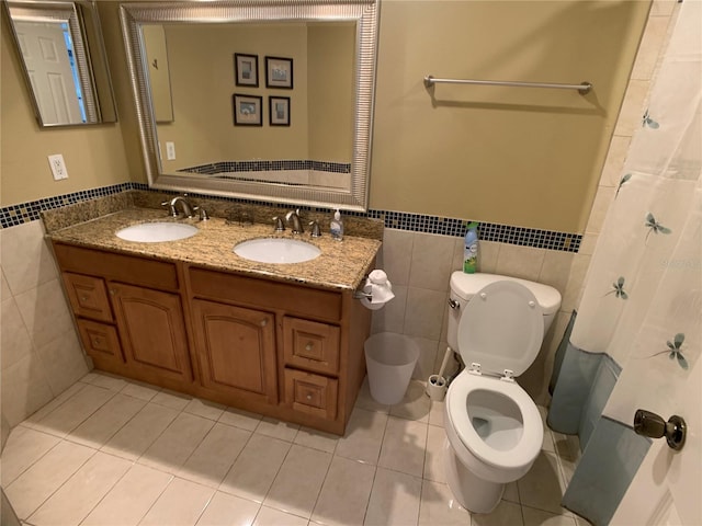 bathroom with tile patterned floors, vanity, toilet, and tile walls