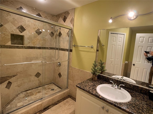 bathroom featuring vanity and a shower with door