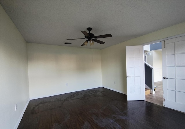 spare room featuring a textured ceiling, ceiling fan, and dark hardwood / wood-style floors