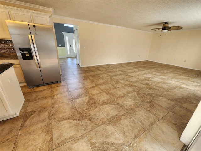 kitchen with ceiling fan, stainless steel refrigerator with ice dispenser, a textured ceiling, and ornamental molding