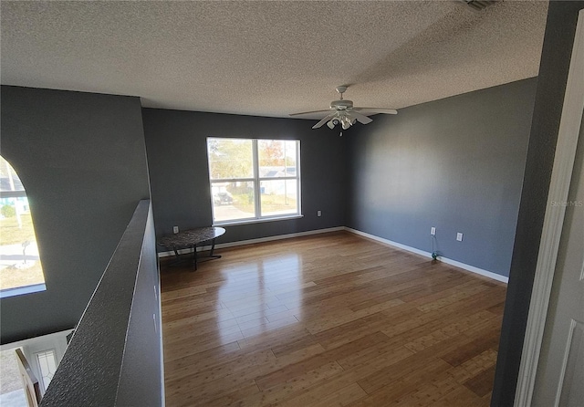 spare room featuring a textured ceiling, ceiling fan, and wood-type flooring