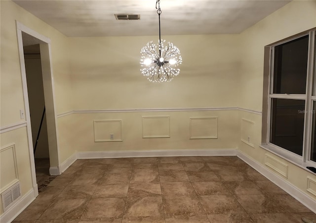 unfurnished dining area with a chandelier