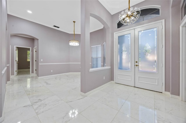 entrance foyer featuring french doors and an inviting chandelier