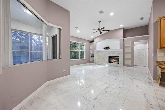 living room featuring ceiling fan and a stone fireplace