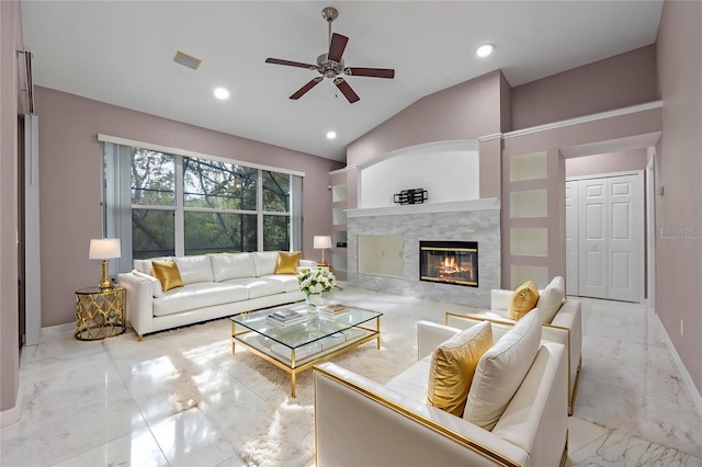 living room with ceiling fan, a tile fireplace, and vaulted ceiling