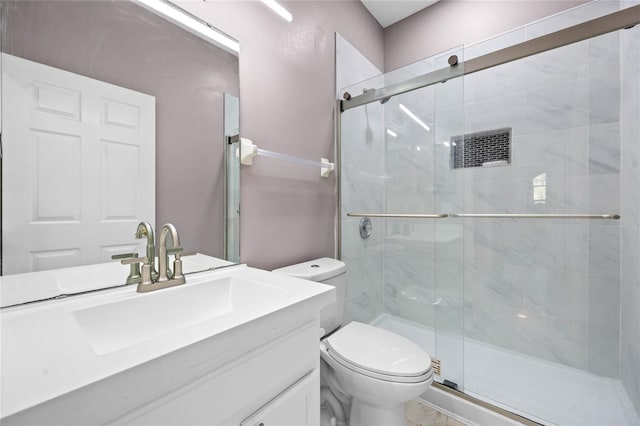 bathroom with vanity, toilet, and a shower with shower door