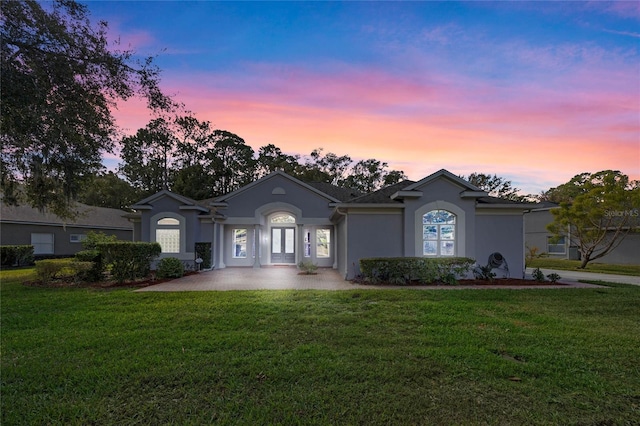 single story home with a lawn