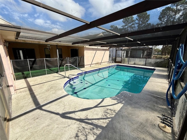 view of pool featuring glass enclosure and a patio area