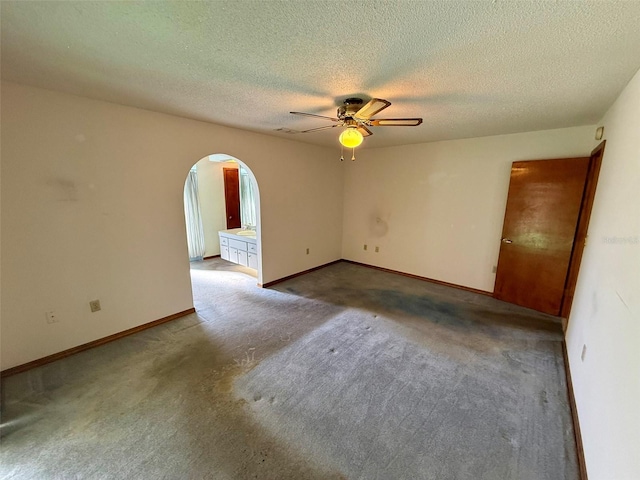 carpeted empty room with ceiling fan and a textured ceiling