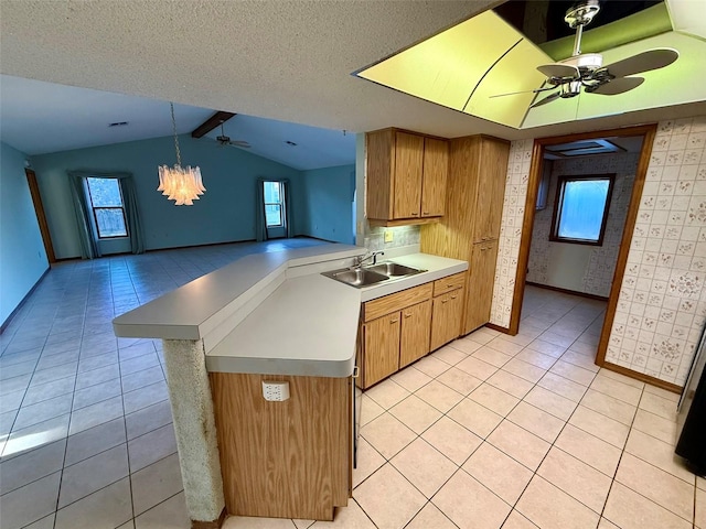 kitchen with pendant lighting, light tile patterned flooring, kitchen peninsula, and sink