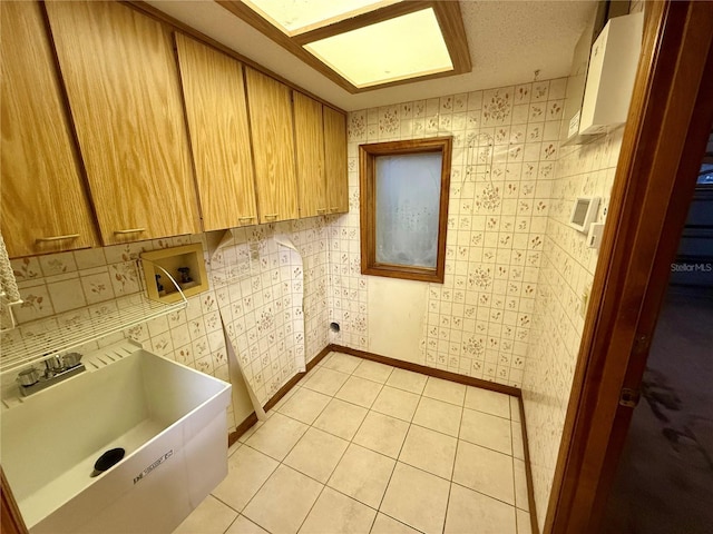 washroom featuring cabinets, light tile patterned floors, sink, and hookup for a washing machine