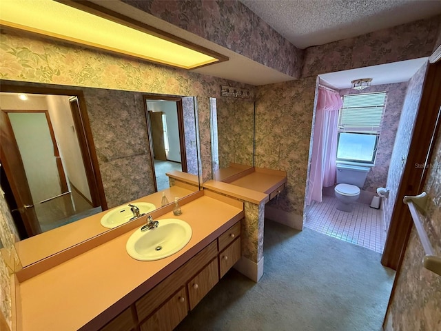 bathroom with vanity, toilet, and a textured ceiling