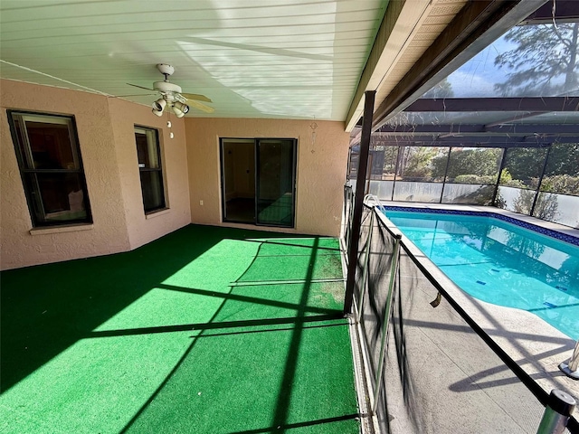 view of pool featuring glass enclosure and ceiling fan