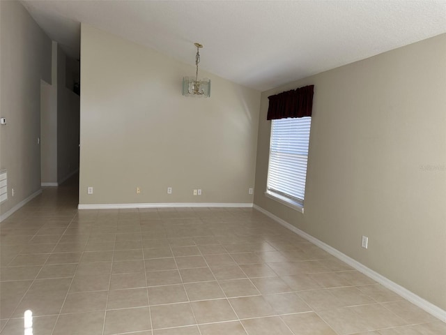 tiled empty room featuring vaulted ceiling and an inviting chandelier