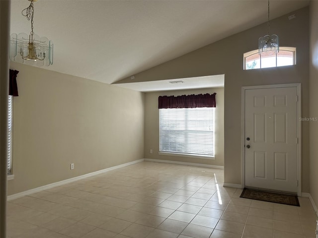 tiled foyer entrance with a chandelier, vaulted ceiling, and a healthy amount of sunlight