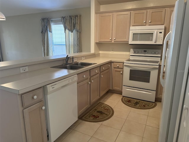 kitchen featuring kitchen peninsula, white appliances, sink, and light tile patterned floors