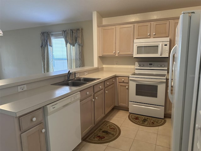 kitchen featuring kitchen peninsula, light tile patterned floors, white appliances, and sink