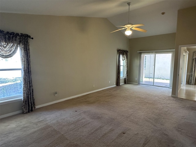 carpeted spare room with vaulted ceiling, a wealth of natural light, and ceiling fan