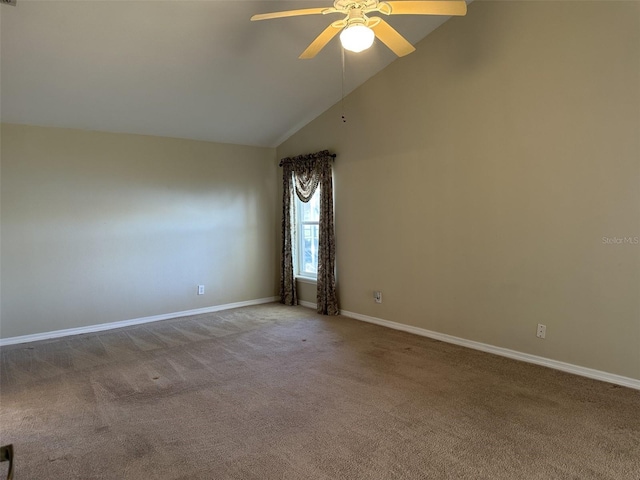 carpeted empty room with ceiling fan and high vaulted ceiling