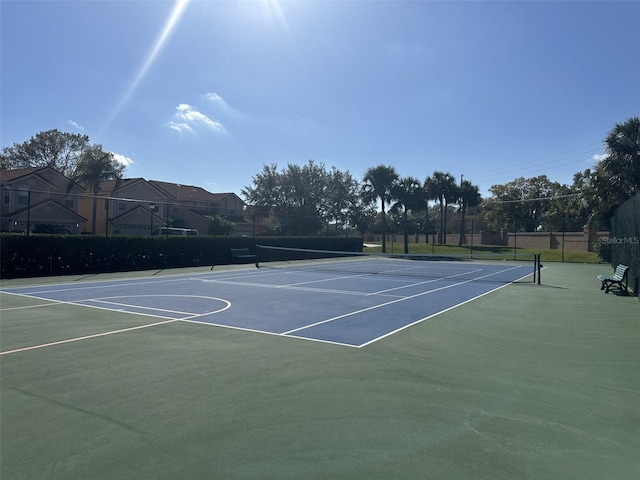 view of tennis court with basketball hoop