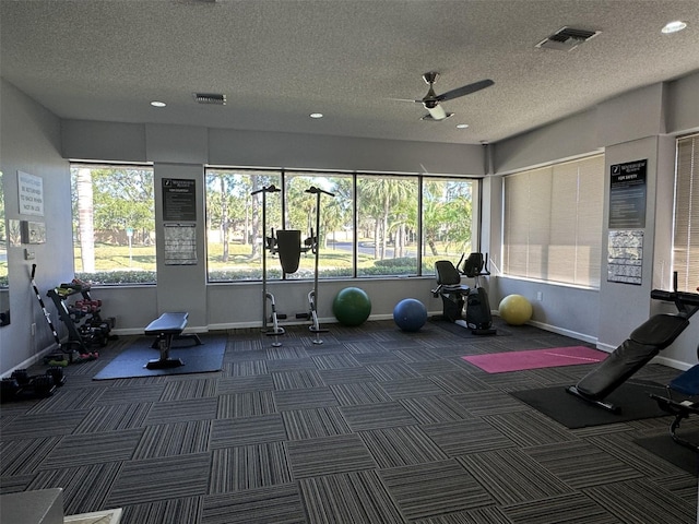 exercise room with a textured ceiling, ceiling fan, and a healthy amount of sunlight