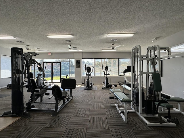 gym with ceiling fan and a textured ceiling