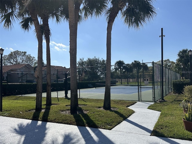 view of tennis court with a lawn