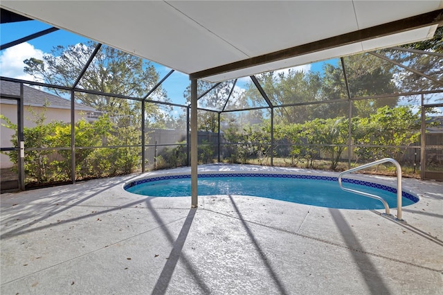 view of swimming pool featuring glass enclosure and a patio