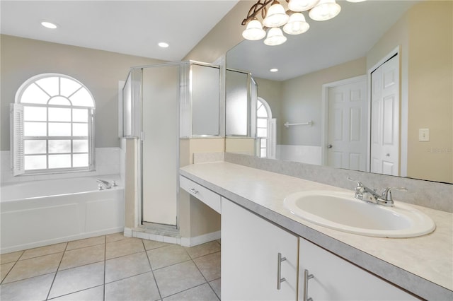 bathroom with tile patterned flooring, shower with separate bathtub, vanity, and a notable chandelier