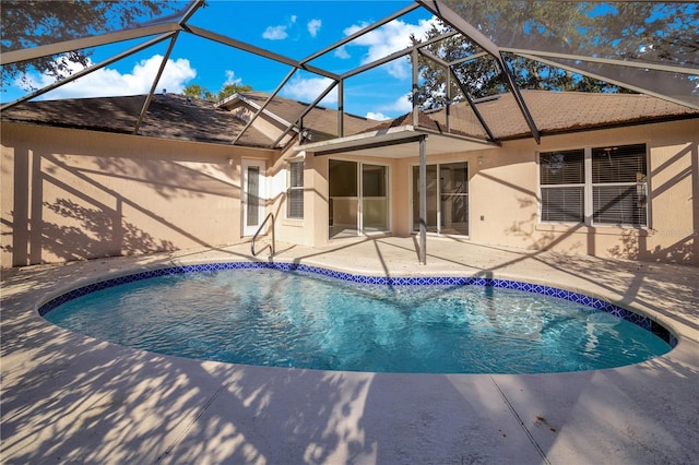 view of swimming pool with glass enclosure and a patio area