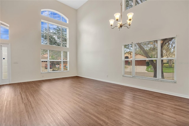 interior space with a towering ceiling, hardwood / wood-style flooring, and a notable chandelier