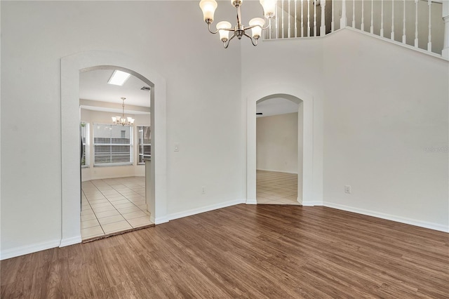 unfurnished room with wood-type flooring and a notable chandelier