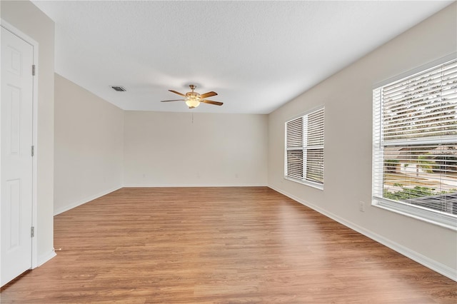 spare room with light wood-type flooring and ceiling fan