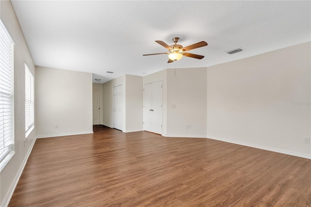 unfurnished room with ceiling fan and dark wood-type flooring