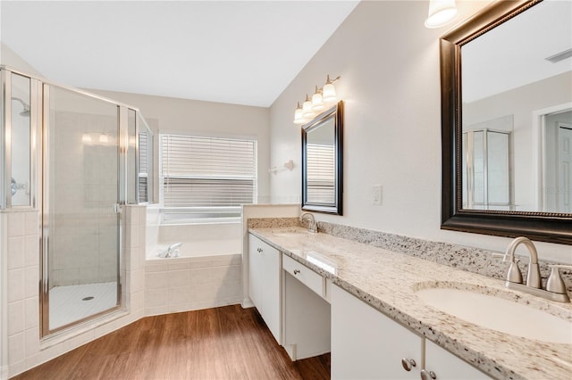 bathroom with hardwood / wood-style flooring, vanity, and shower with separate bathtub