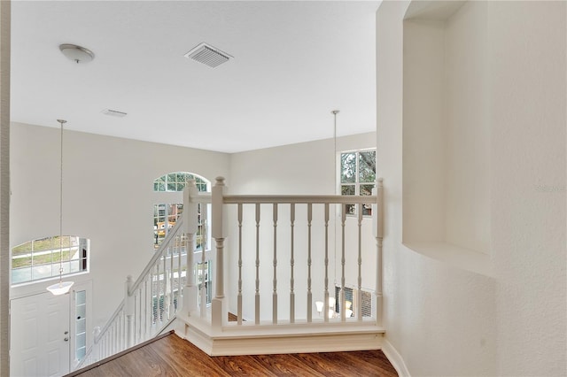 hallway with hardwood / wood-style flooring and an inviting chandelier