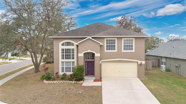 view of front of home featuring ac unit, a front yard, and a garage