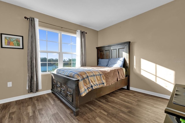 bedroom featuring hardwood / wood-style floors and a water view