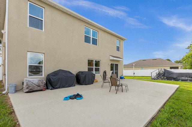 rear view of house featuring a yard and a patio