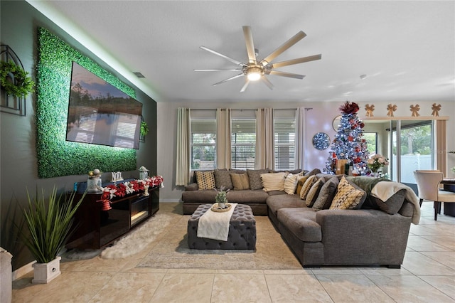 living room featuring ceiling fan, plenty of natural light, and light tile patterned floors