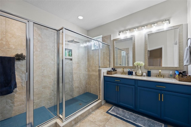 bathroom featuring tile patterned flooring, vanity, a textured ceiling, and walk in shower