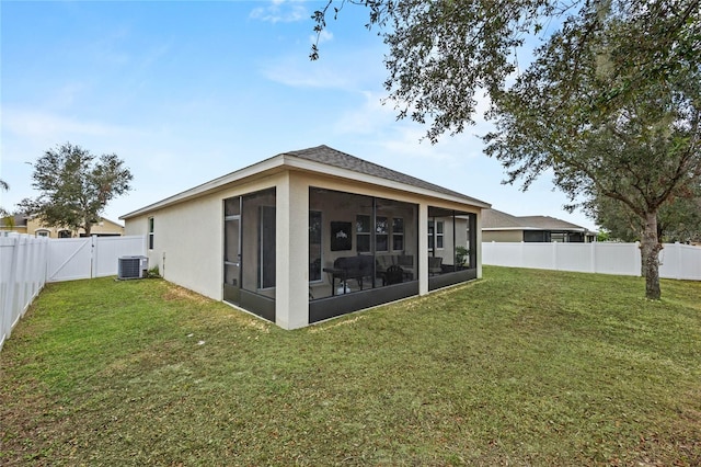 rear view of property featuring a sunroom, cooling unit, and a yard