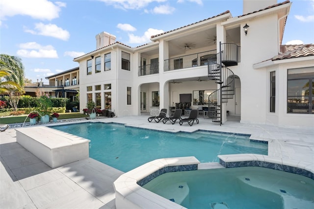 view of pool featuring pool water feature, ceiling fan, an in ground hot tub, and a patio