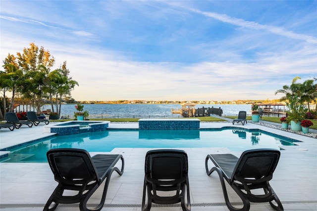 view of swimming pool with an in ground hot tub, a playground, and a water view