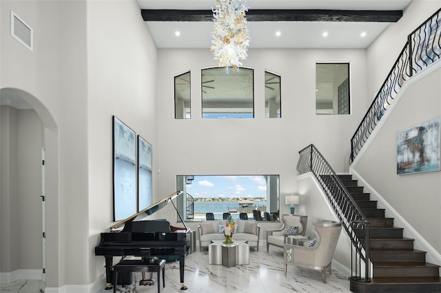 interior space featuring beam ceiling and a high ceiling