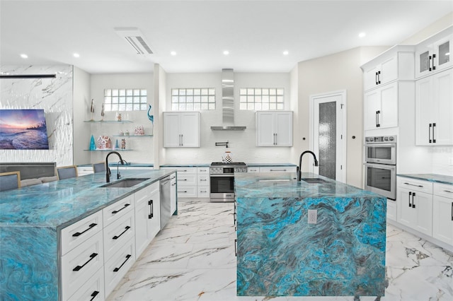 kitchen with a large island with sink, sink, dark stone countertops, and wall chimney exhaust hood