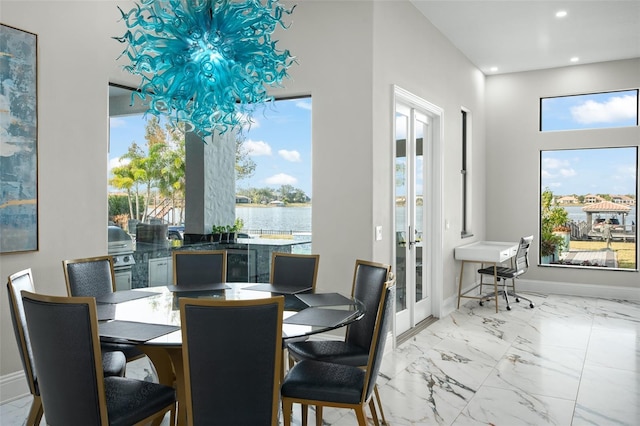 dining space with a water view, plenty of natural light, and french doors