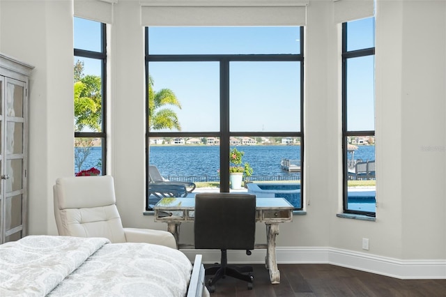 bedroom featuring a water view and hardwood / wood-style floors