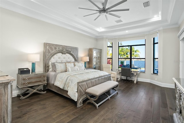 bedroom with a tray ceiling, dark wood-type flooring, ornamental molding, and ceiling fan